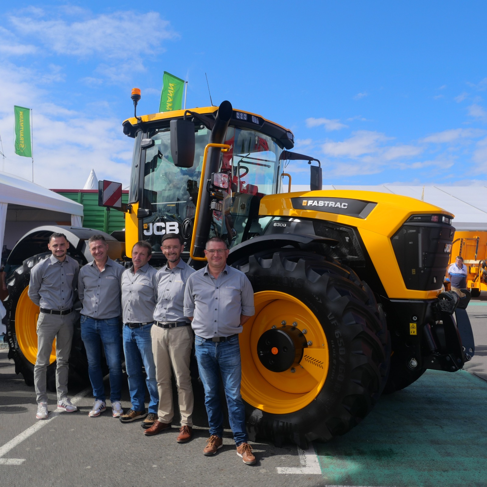 L'équipe commerciale de Bernard Manutention Agri posant devant le nouveau tracteur jaune JCB Fastrac 6300 au salon Space.
